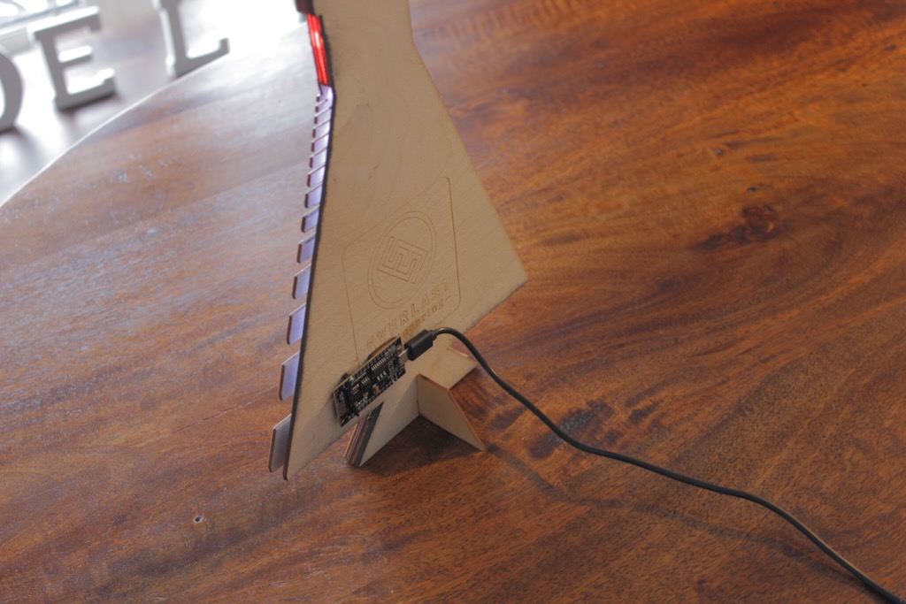 Rear of the wooden locomotive art piece showing laser cut edges, etched branding, and the LED control board